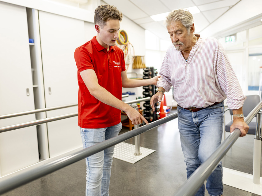 Fysiotherapeut helpt klant met lopen